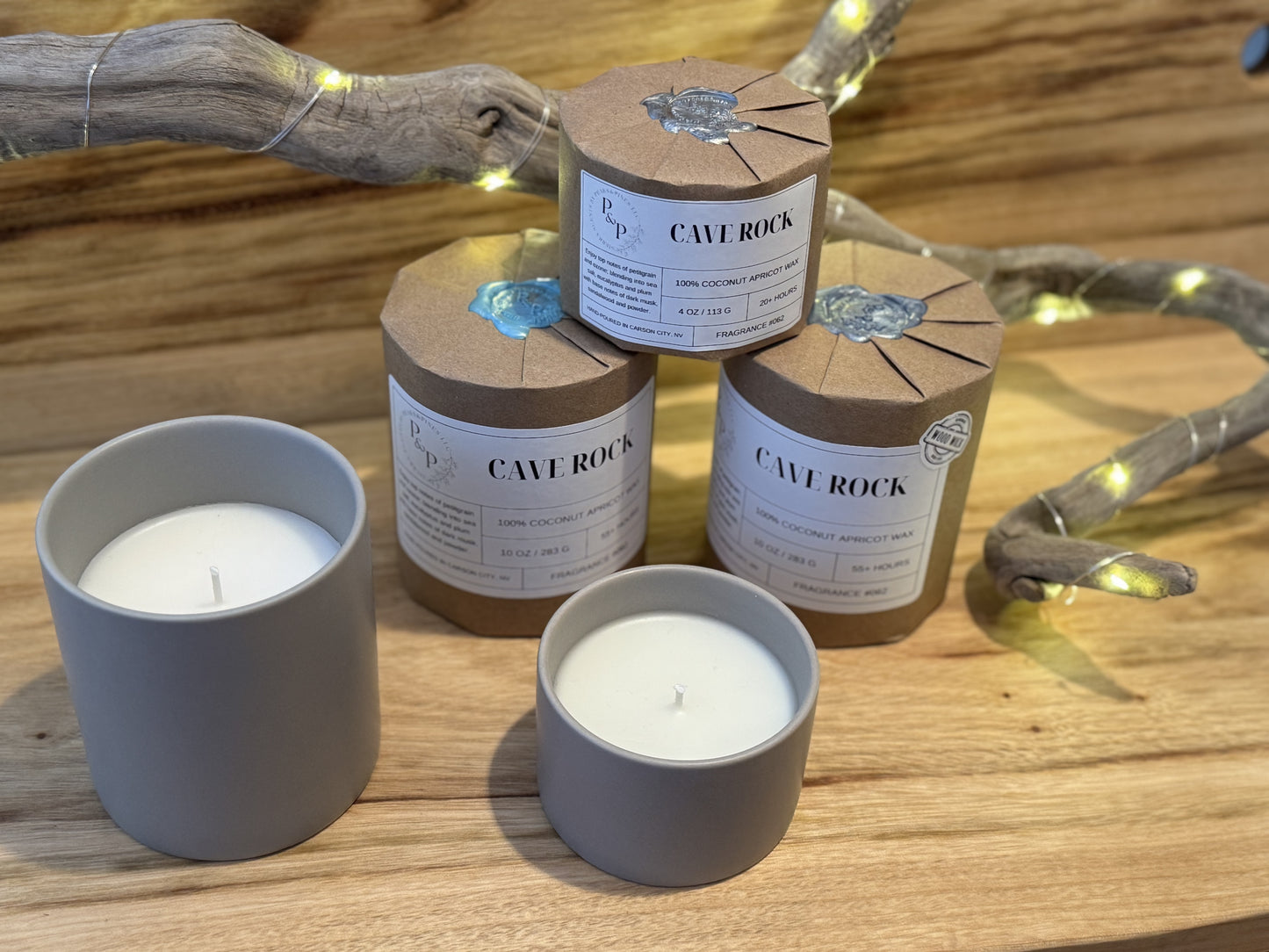 3 Wrapped Cave Rock candles. Two are 10 oz candles and 1 is a 4oz candle. All are wrapped with wax seal, gift-ready packaging by Peaks and Pines. There are also 2 unwrapped candles showing the grey ceramic vessel. One is a Cave Rock 4oz and one is Cave Rock 10 oz.