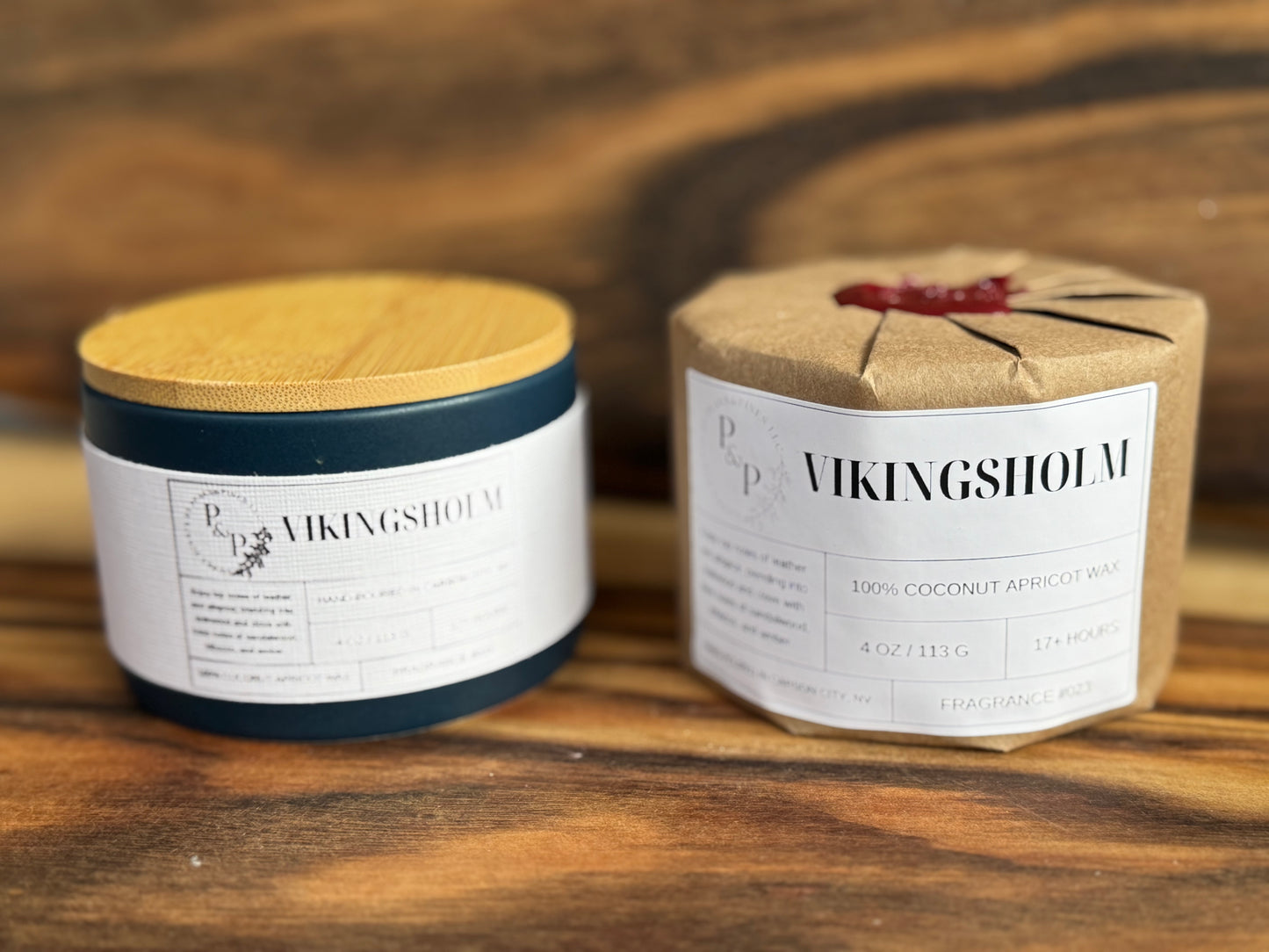 Two Vikingsholm 4 oz candles on a wooden surface, one wrapped in kraft paper with wax seal.