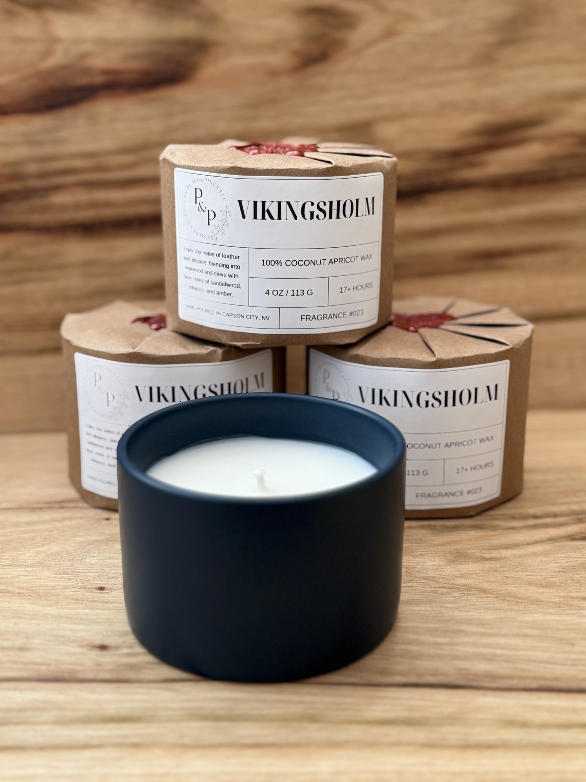 4 Vikingsholm 4 oz ceramic candle by Peaks and Pines. 3 are wrapped and 1 shows the blue ceramic jar with wood lid.
