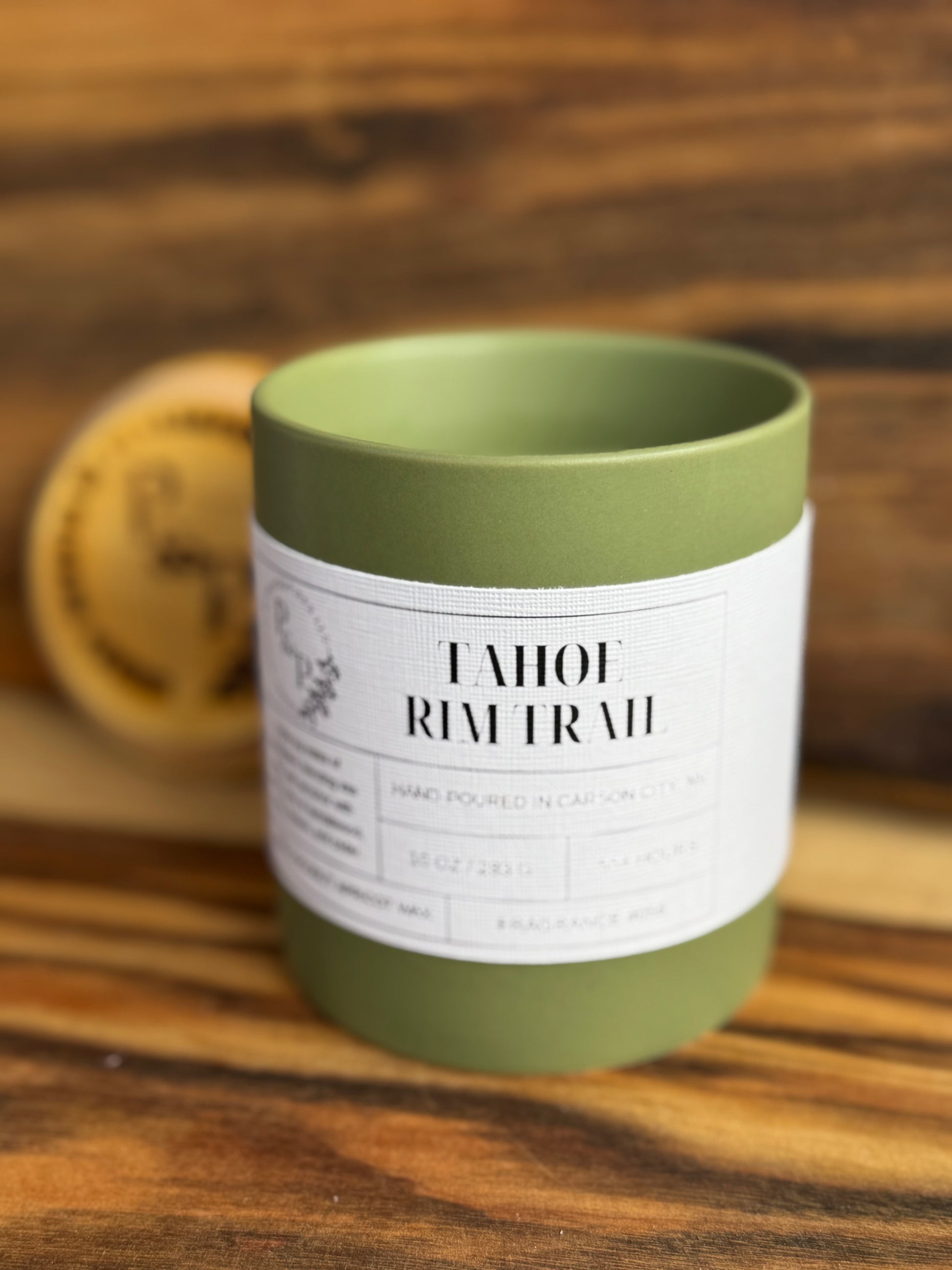 Close up Tahoe Rim Trail 10 oz ceramic candle by Peaks and Pines, ceramic jar with wood lid and white label