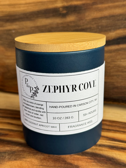 Zephyr Cove 10 oz ceramic candle by Peaks and Pines, blue jar with wood lid and white label