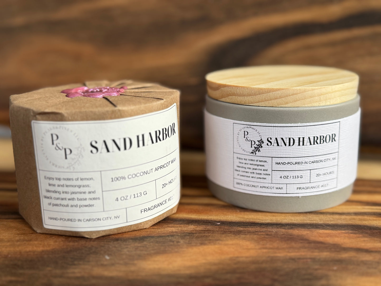 Two Sand Harbor 4 oz candles on a wooden surface, one wrapped with kraft paper and wax seal