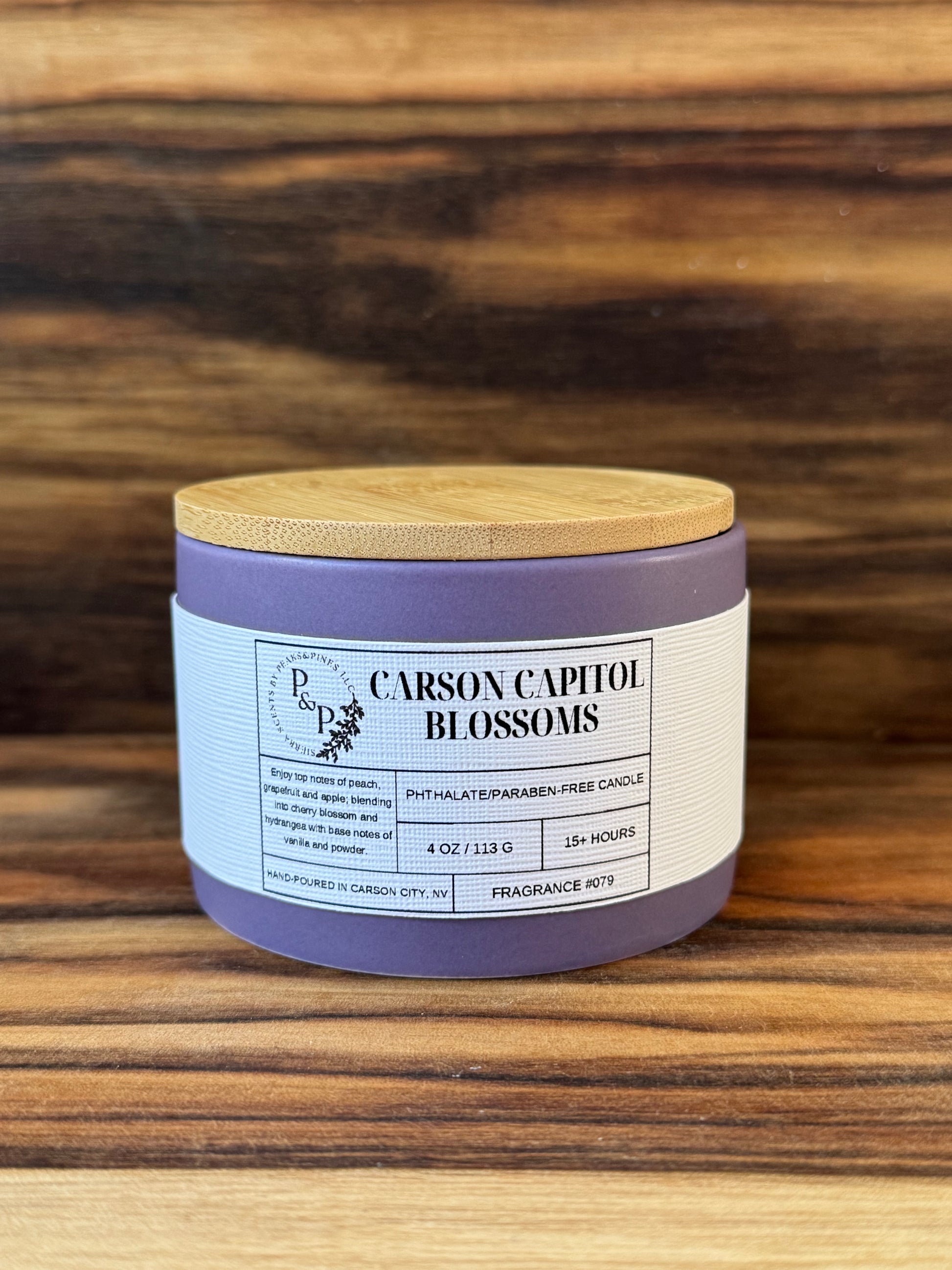 Carson Capitol Blossoms 4 oz ceramic candle by Peaks and Pines, purple ceramic, wood lid and white label. 