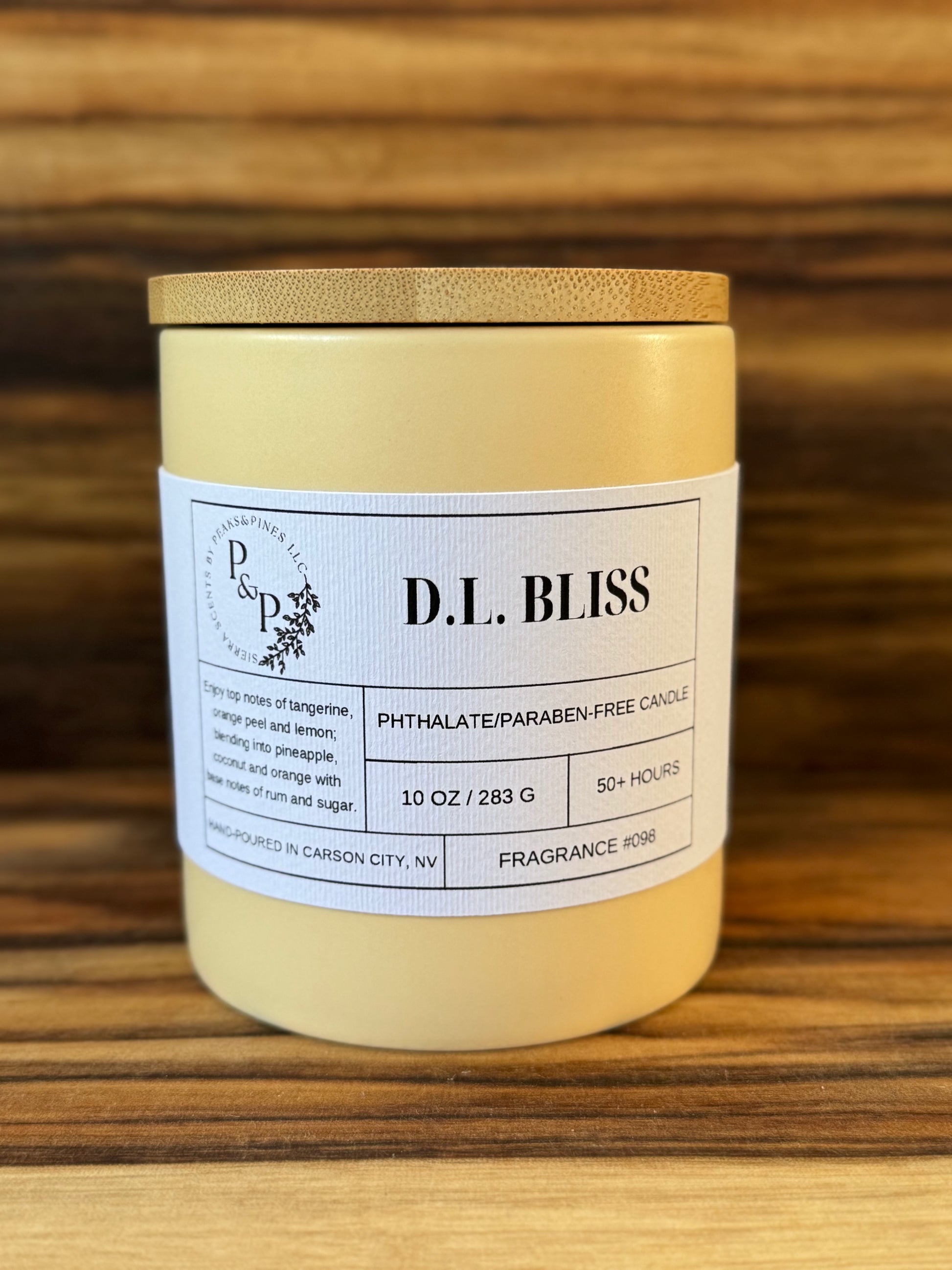 D.L. Bliss 10 oz ceramic candle by Peaks and Pines showing cream ceramic and white label