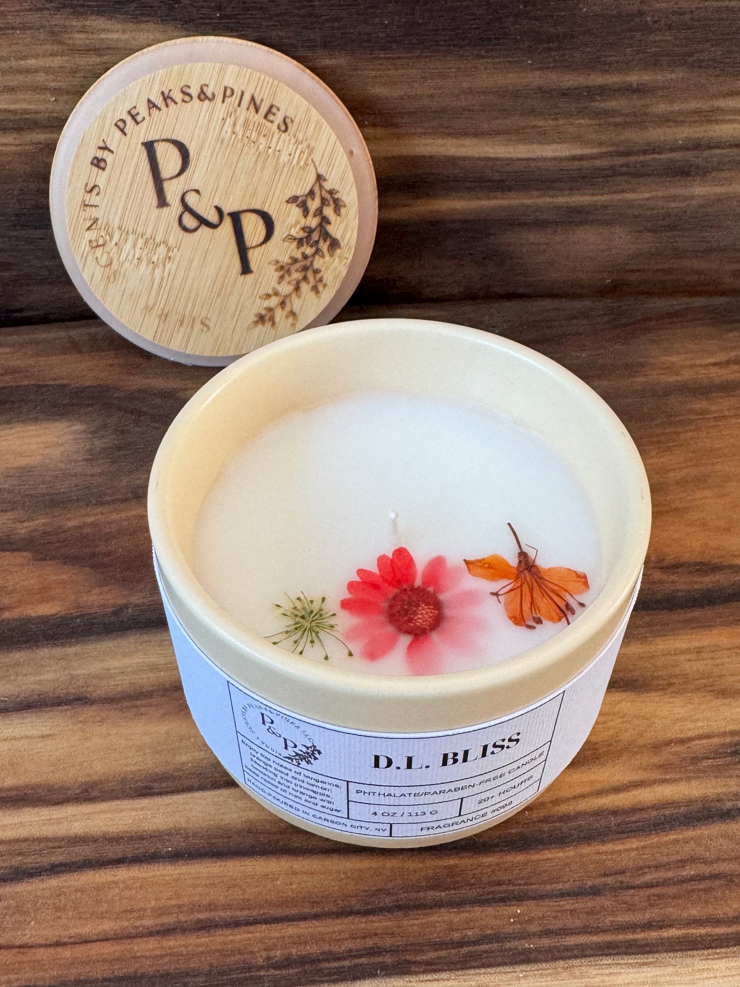 D.L. Bliss 4 oz cream ceramic candle by Peaks and Pines, botanical impressions line with pressed flowers in the wax and branded wood lid