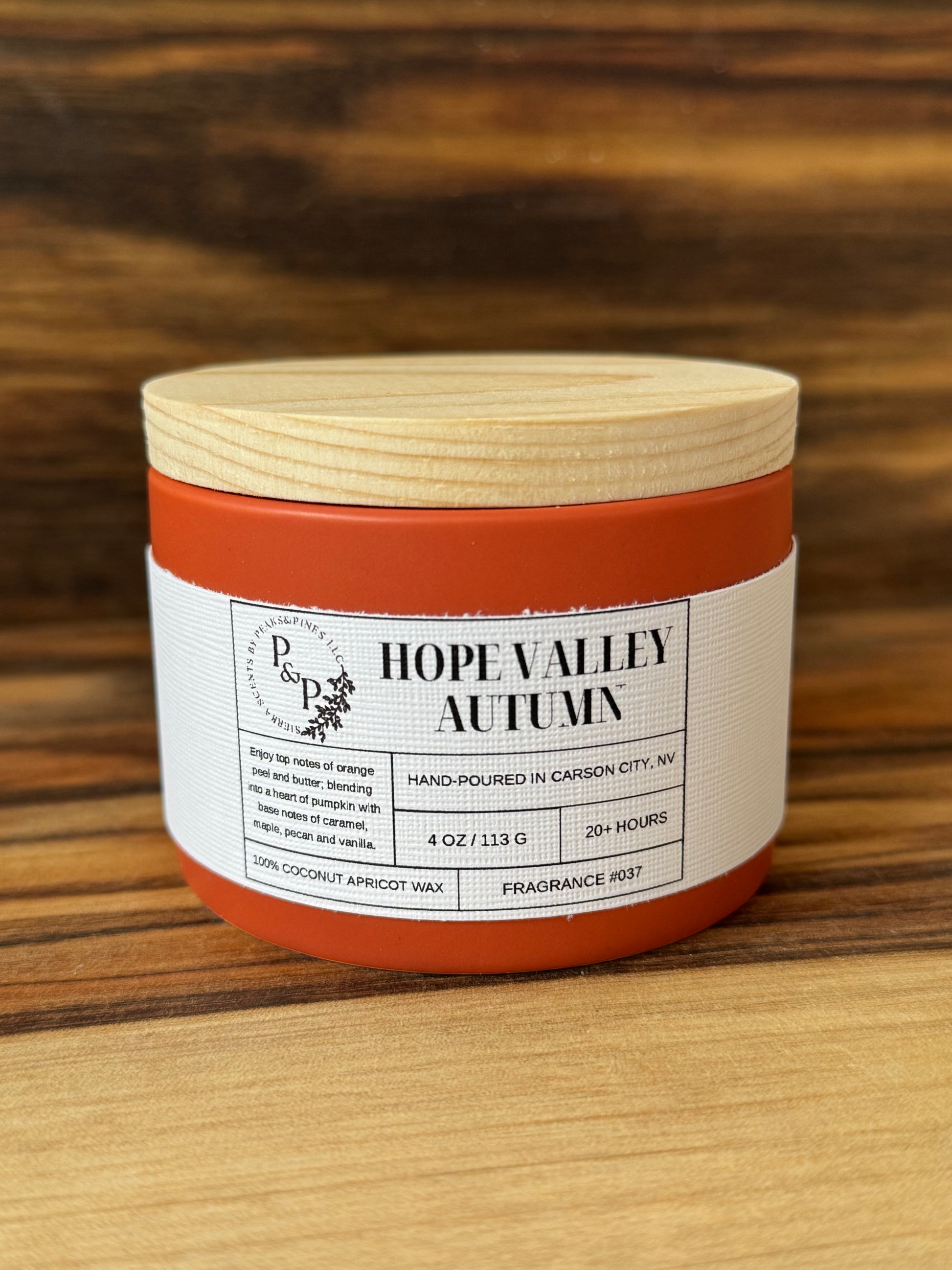 Hope Valley Autumn 4 oz ceramic candle by Peaks and Pines, orange ceramic jar with wood lid and white label